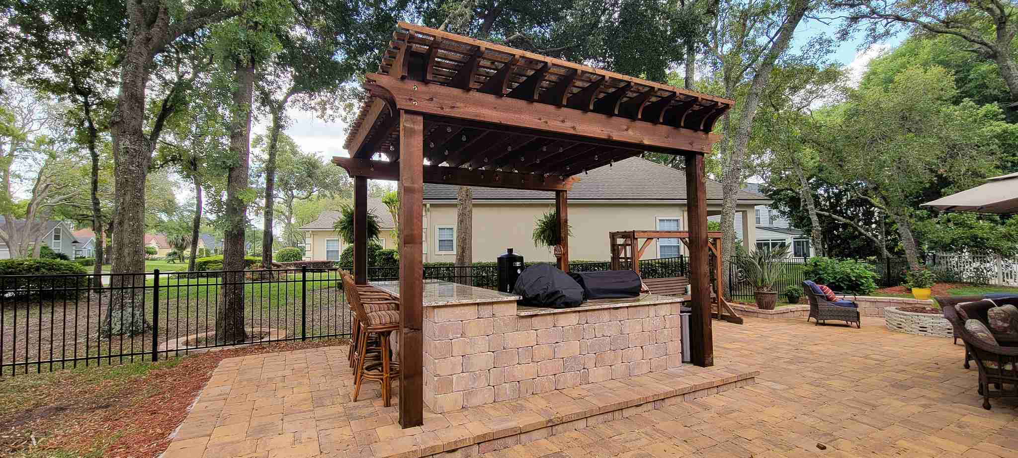 Cedar pergola with outdoor kitchen and stone island
