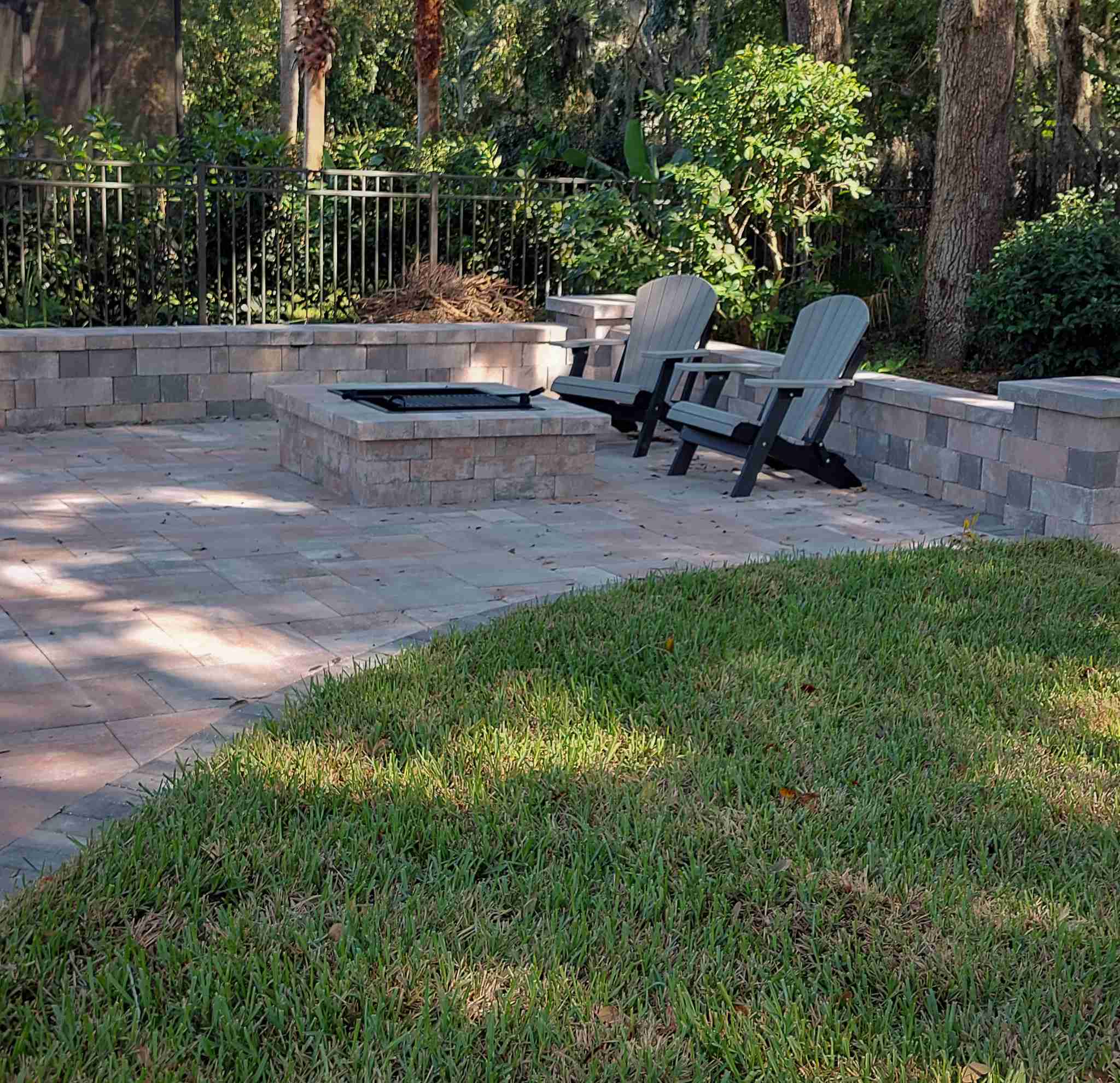 Square fire pit with retaining wall seating and Adirondack chairs