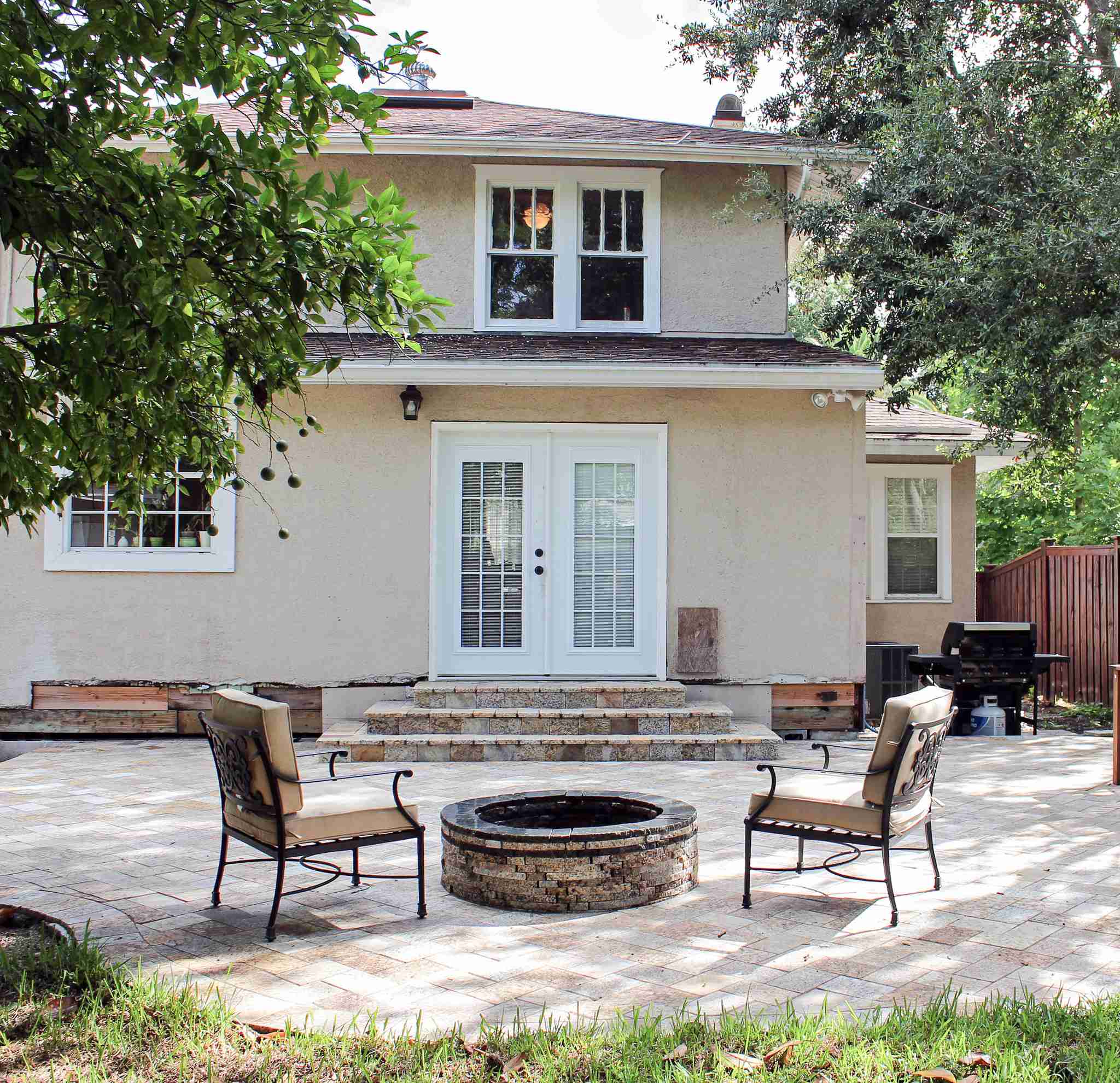 Backyard patio with fire pit and paver steps to home