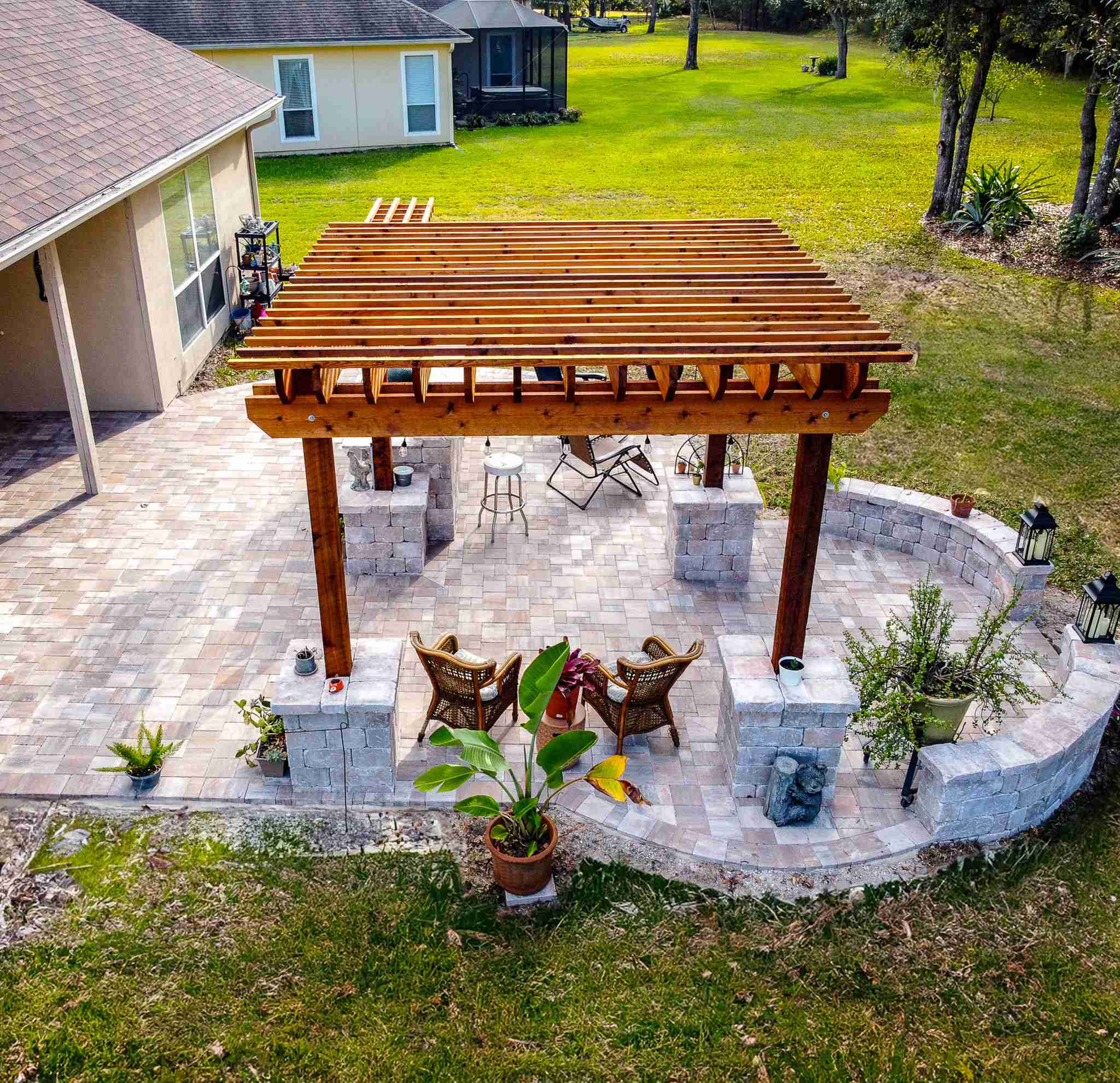 Aerial view of pergola patio with curved retaining wall